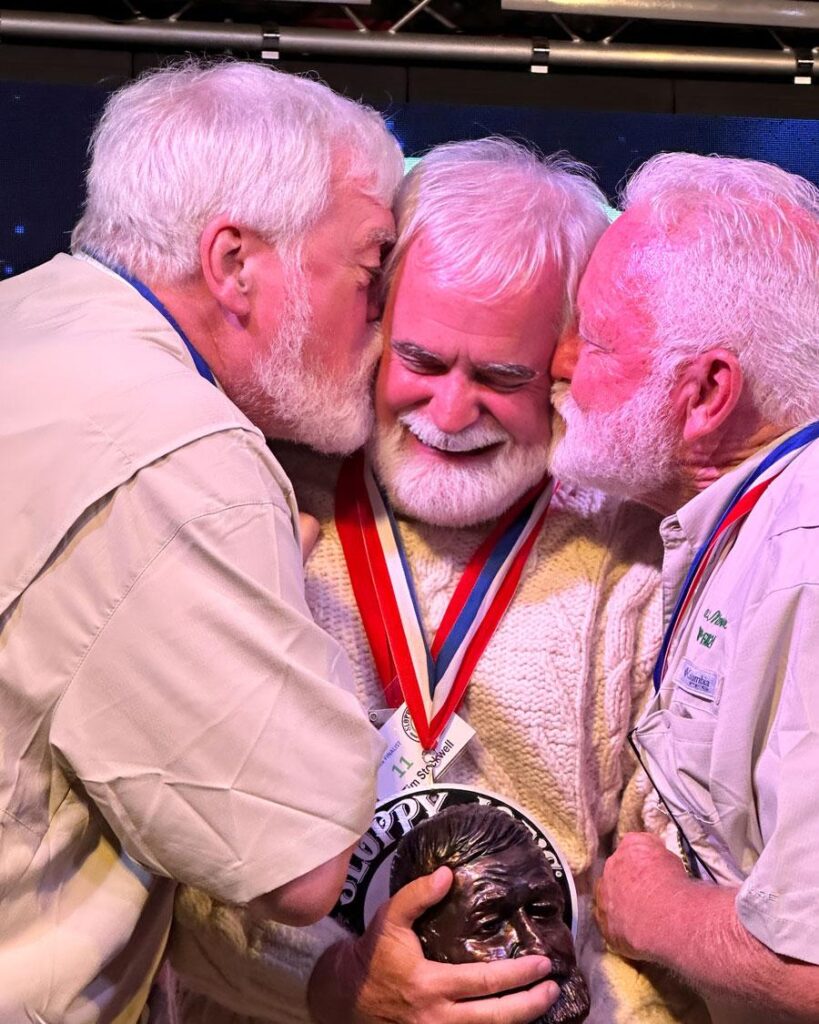 2025 Papa Tim Stockwell receiving a congratulatory kiss by Papa Gerrit and Papa Bat.